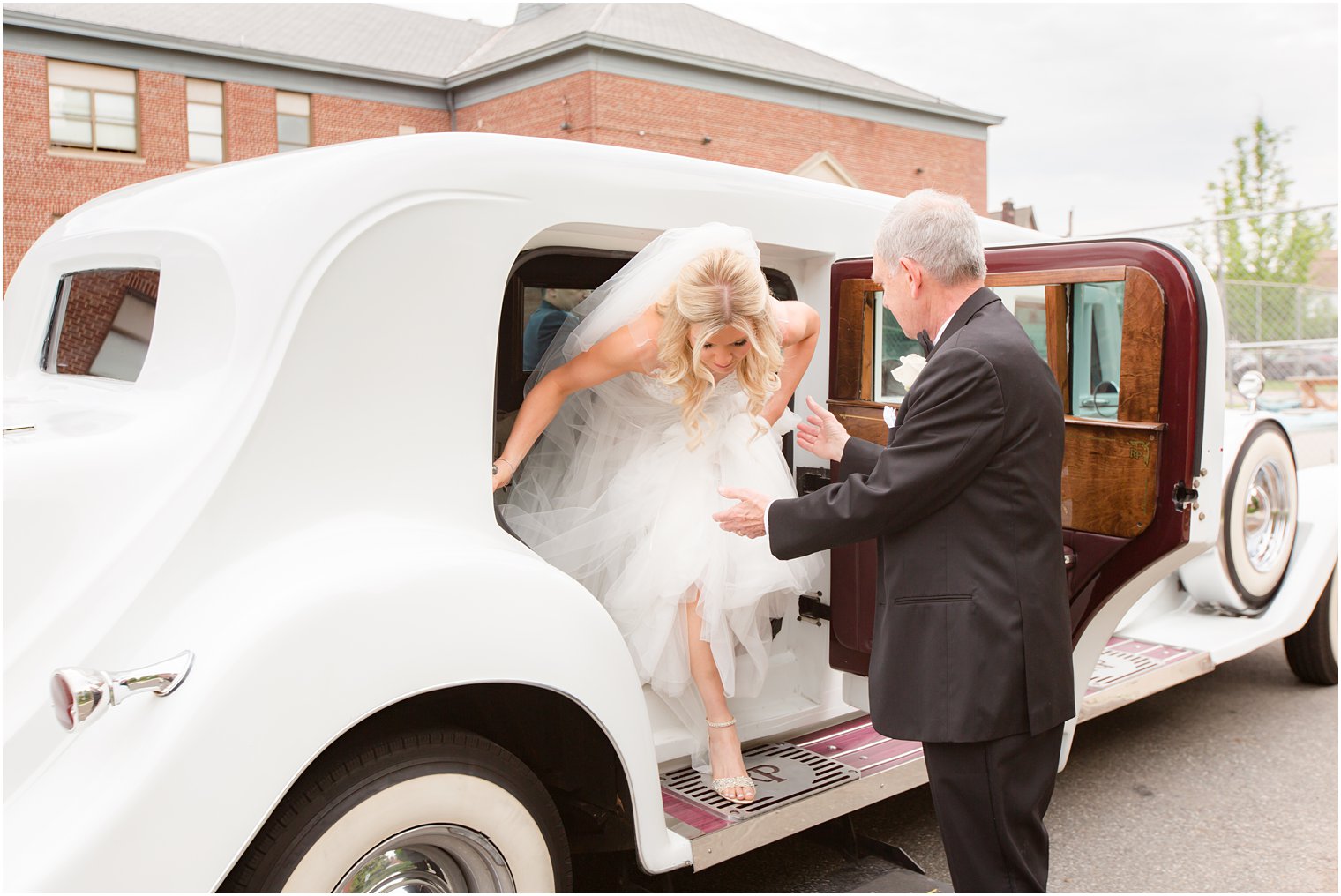bride getting out of classic car with her father