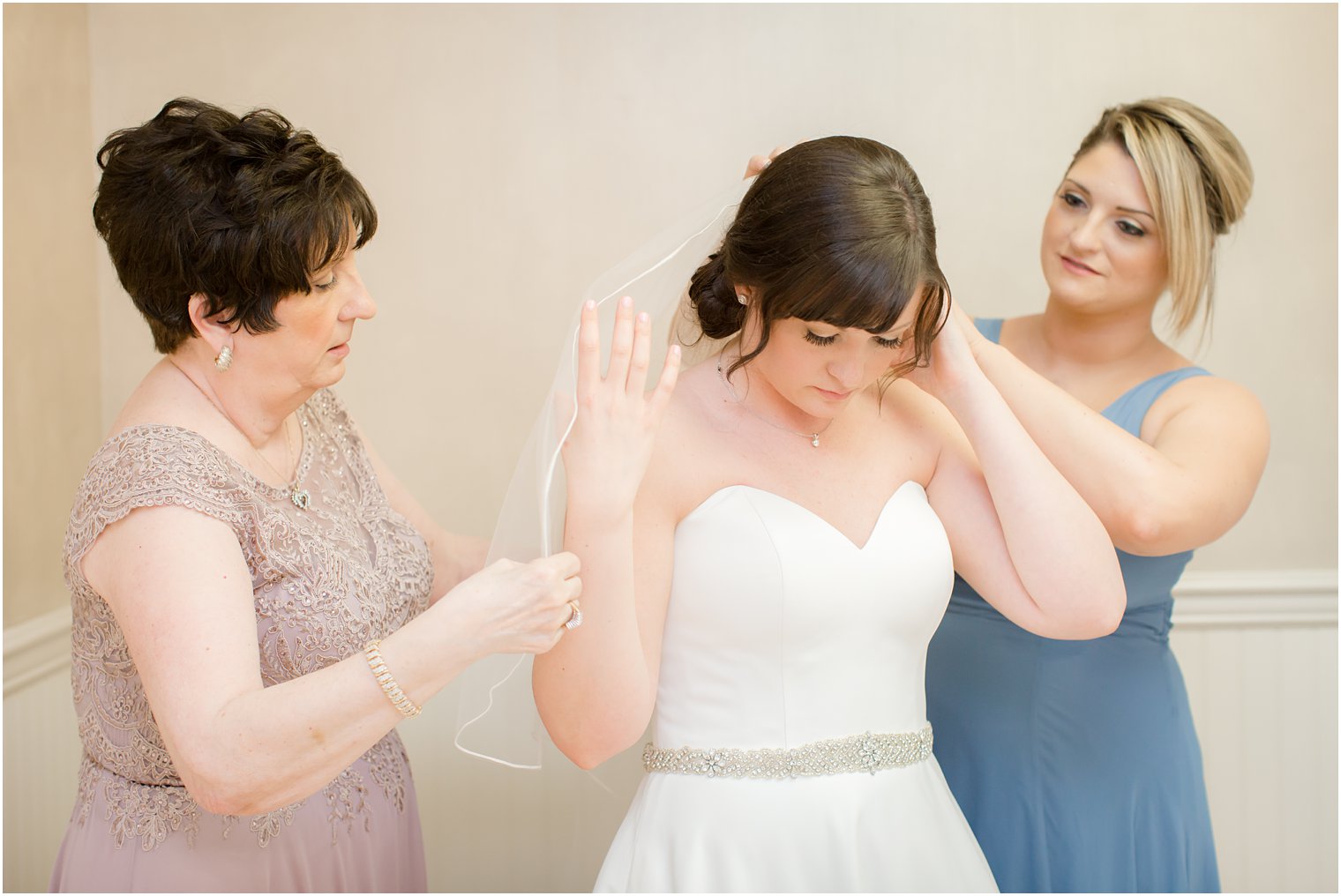 Bride getting ready with her mother and maid of honor
