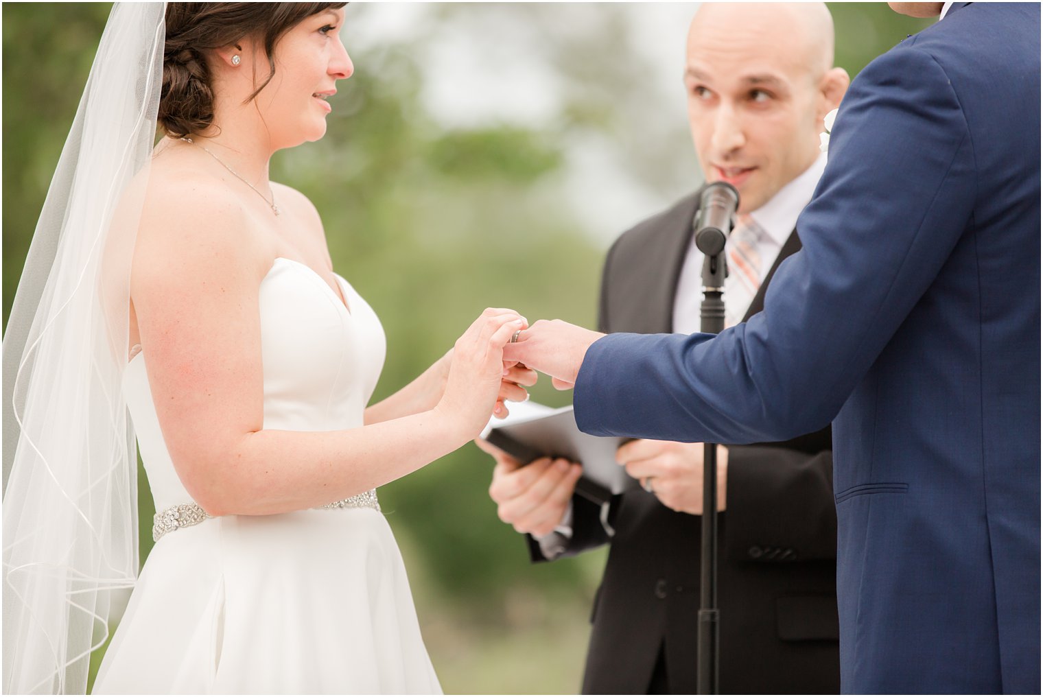 Bride putting on groom's ring at Windows on the Water at Frogbridge in Millstone NJ