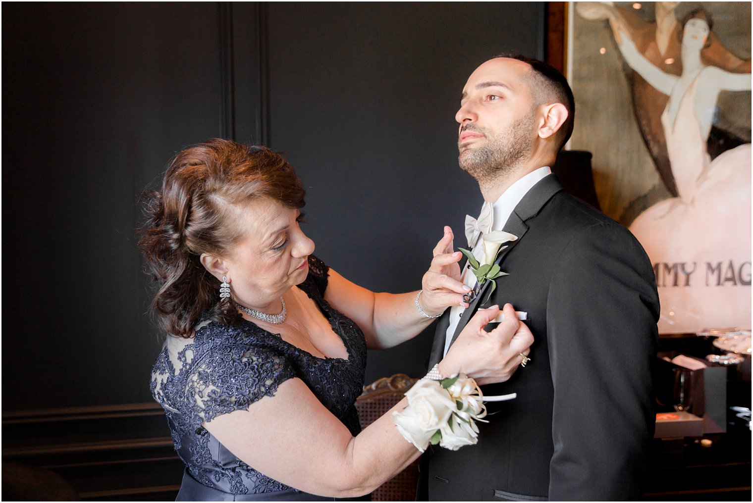 Mother of the groom putting on his boutonniere at Park Chateau Estate Wedding