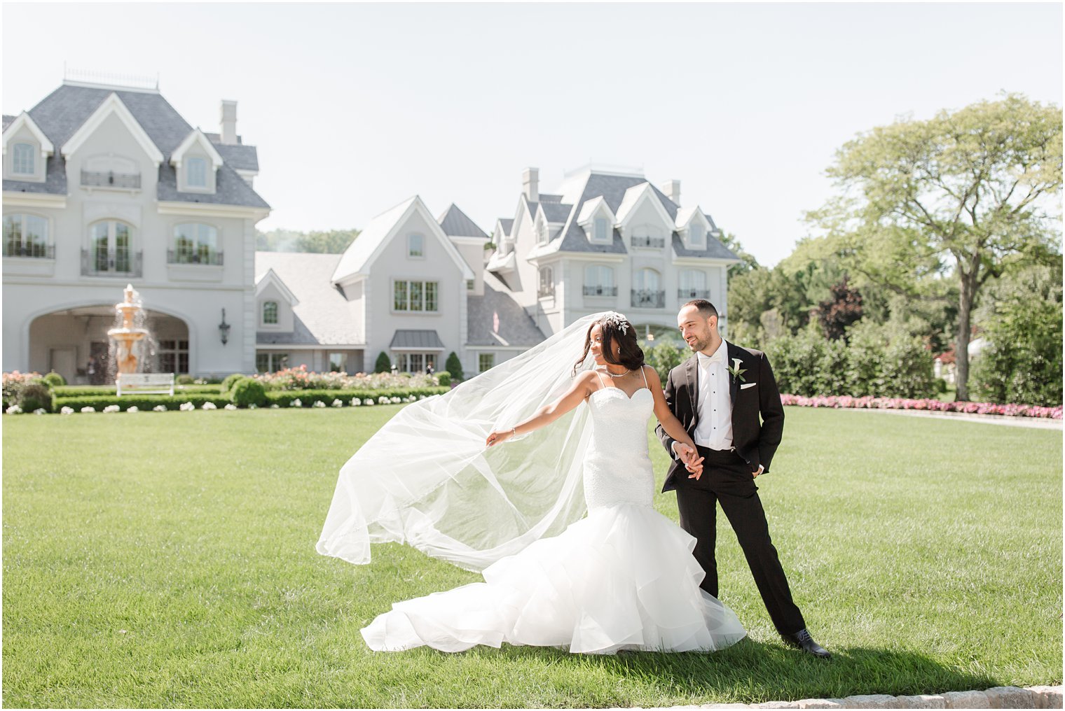 Bride and groom with wind blowing bride's cathedral veil