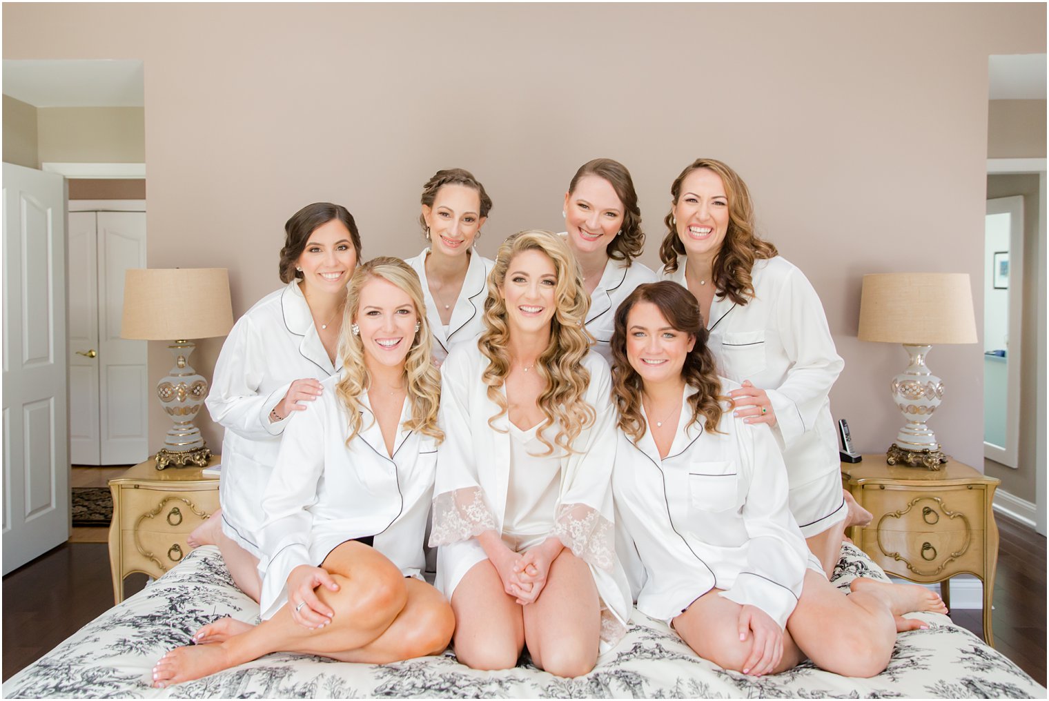 bridesmaids in robes on bed at Indian Trail Club Wedding