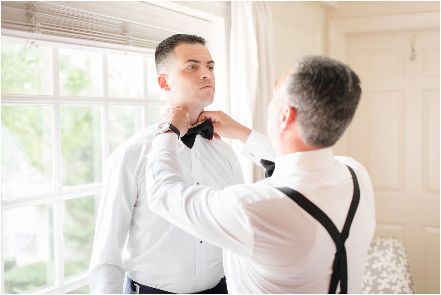 Groom's father putting on his bowtie