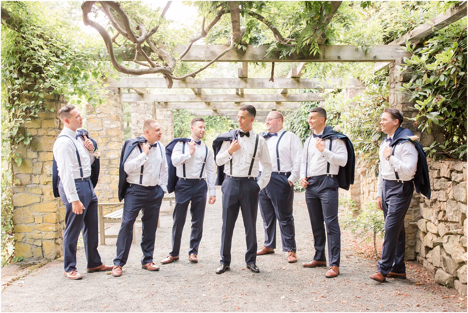 Groom and groomsmen wearing blue tuxedos and suspenders