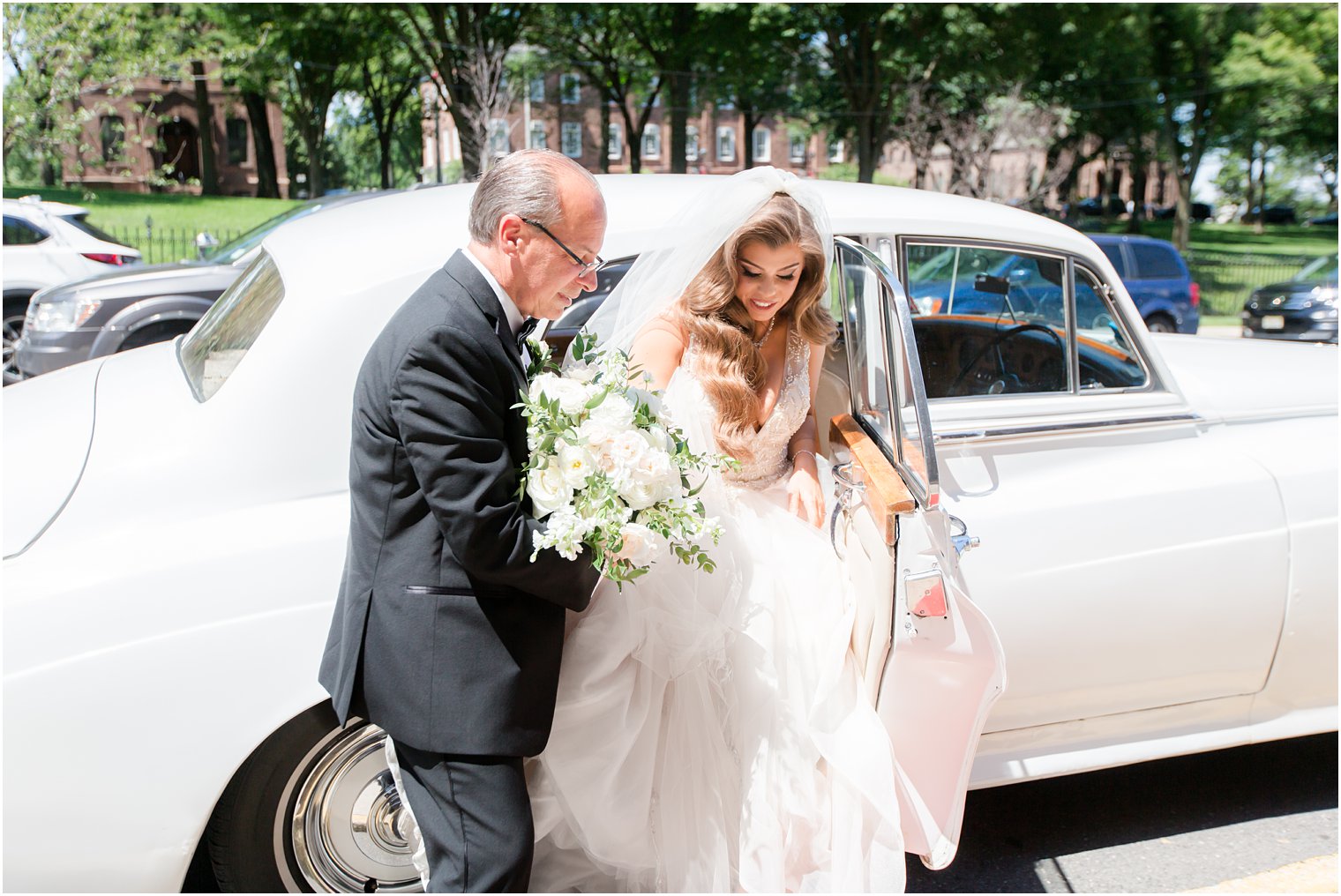 Father of the bride helping bride out of Rolls Royce at St. Peter the Apostle in New Brunswick NJ