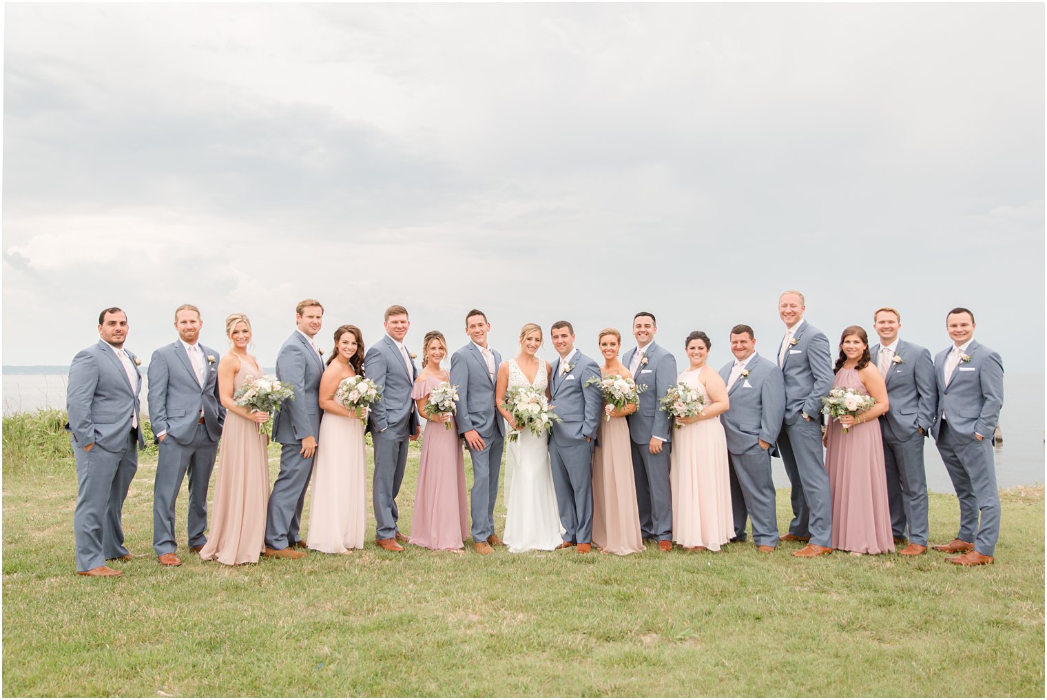 wedding party with pink, peach, and gray attire photographed by Idalia Photography