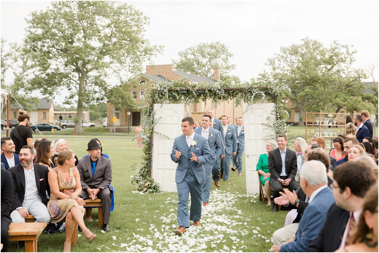 groom enters wedding ceremony at Sandy Hook Chapel photographed by Idalia Photography