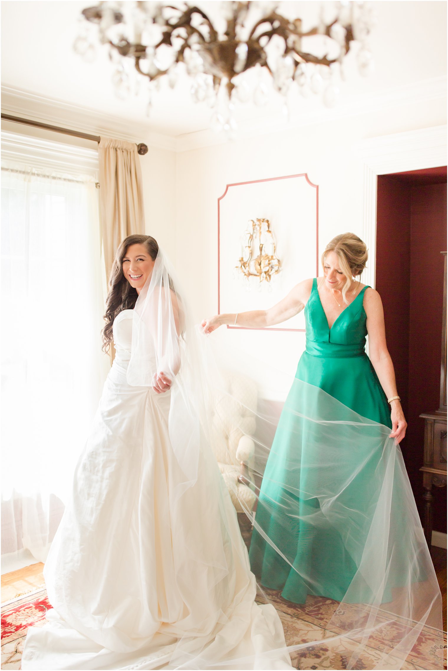 Mother of the bride putting on bride's veil