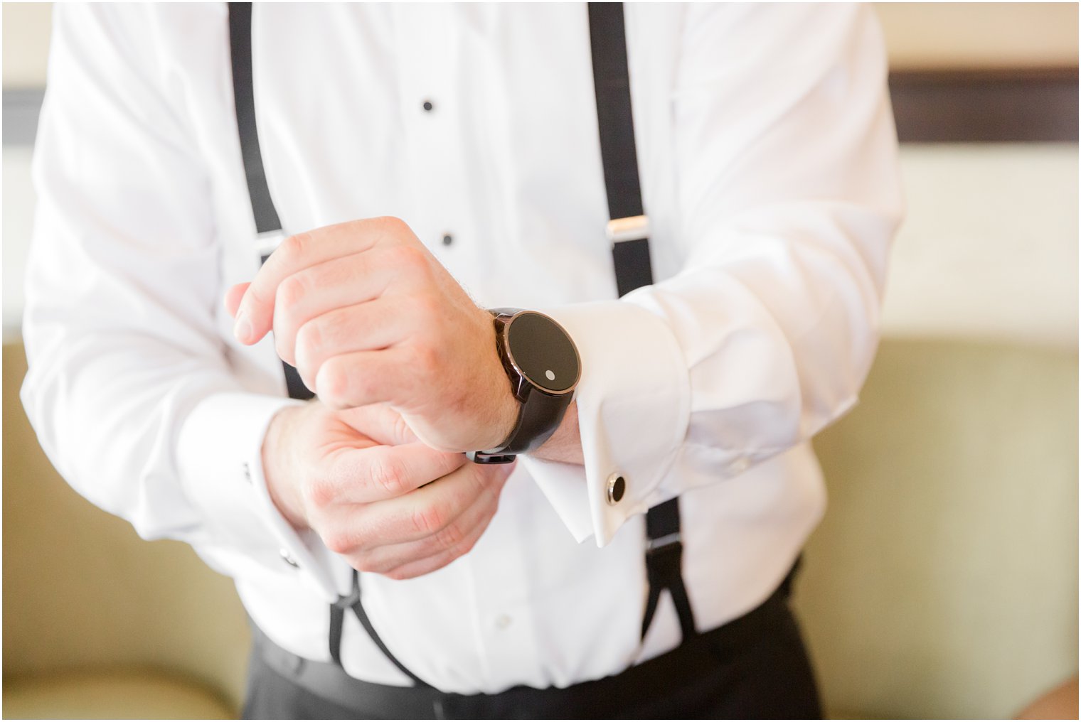 Groom putting on his watch on wedding day