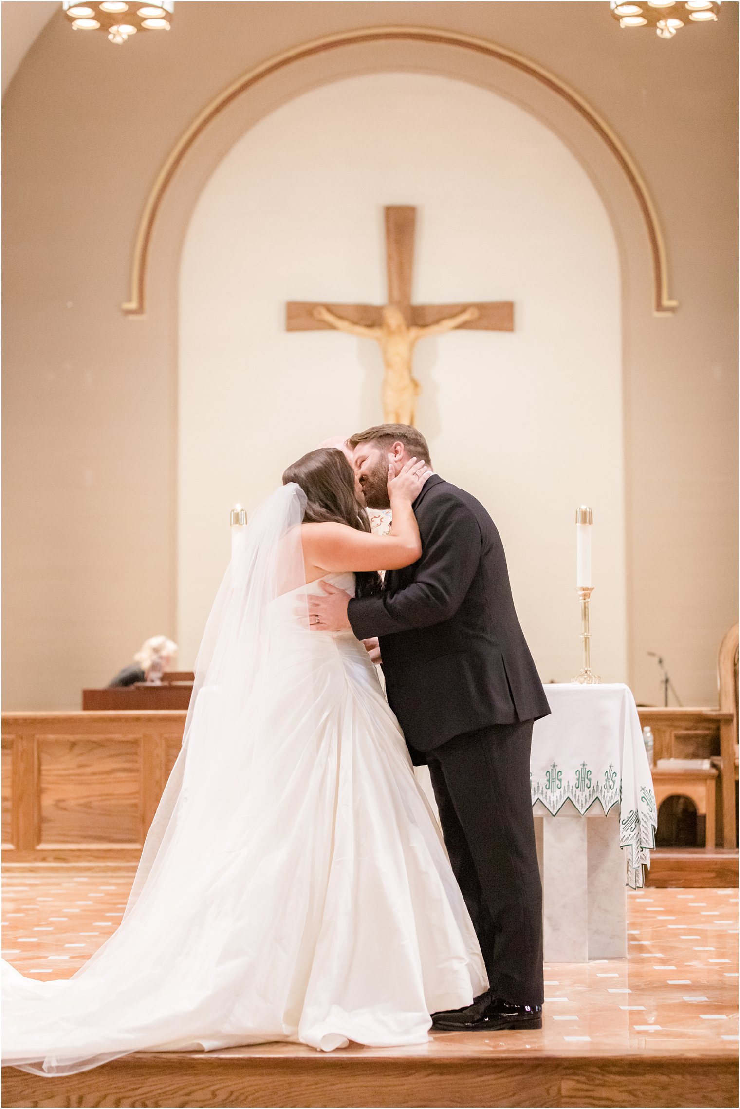 Bride and groom kissing at the altar in St. Luke's Church in Ho-Ho-Kus