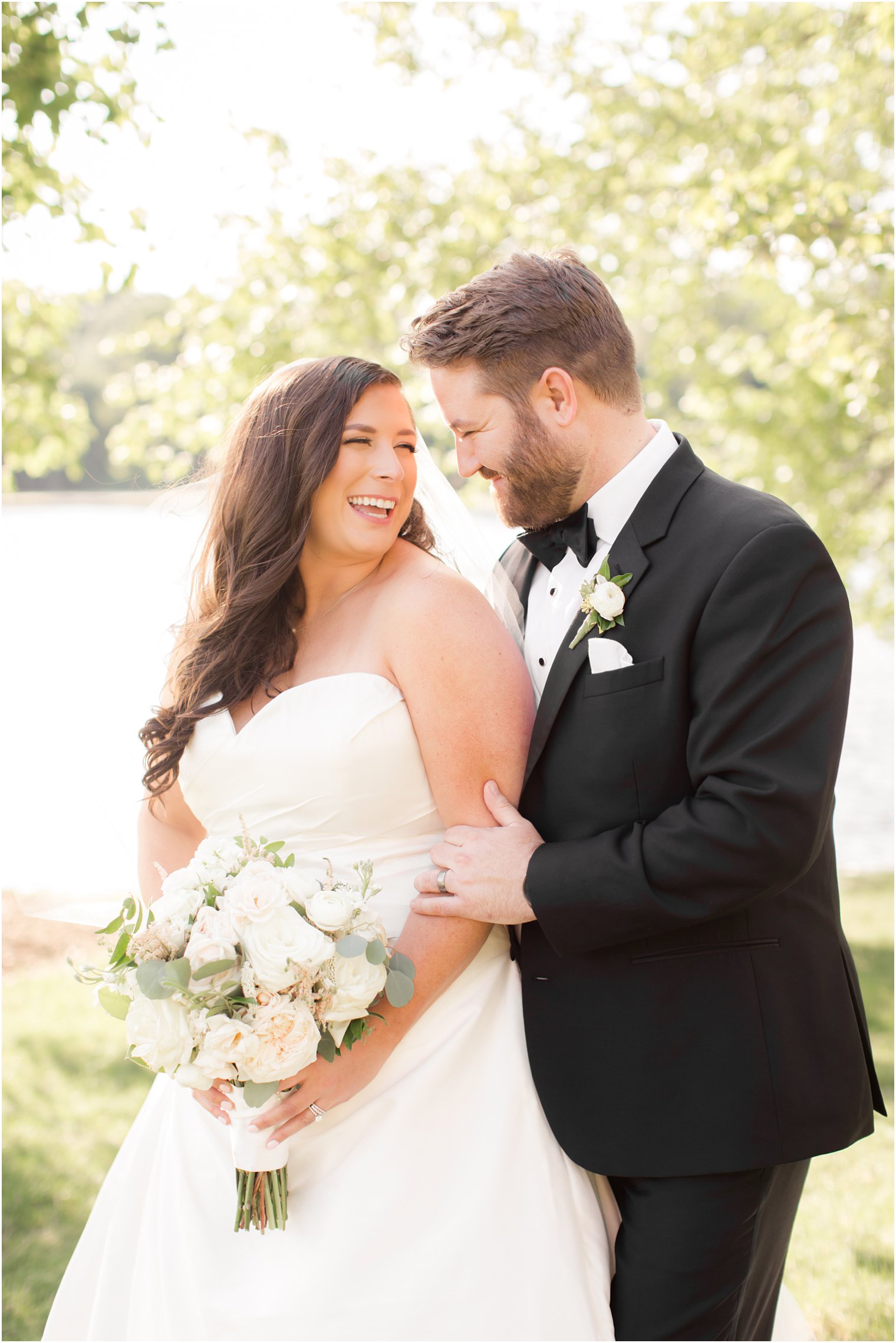 Bride and groom smiling at each other during wedding portraits