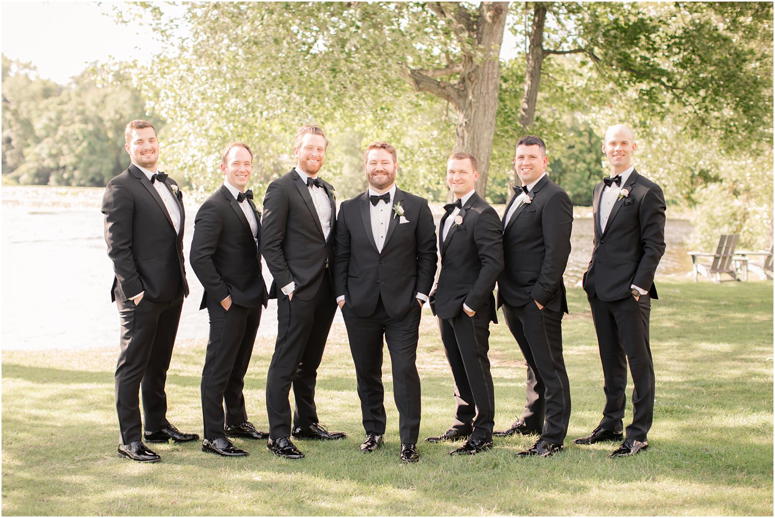 Groom and groomsmen in black tuxedos and bow ties