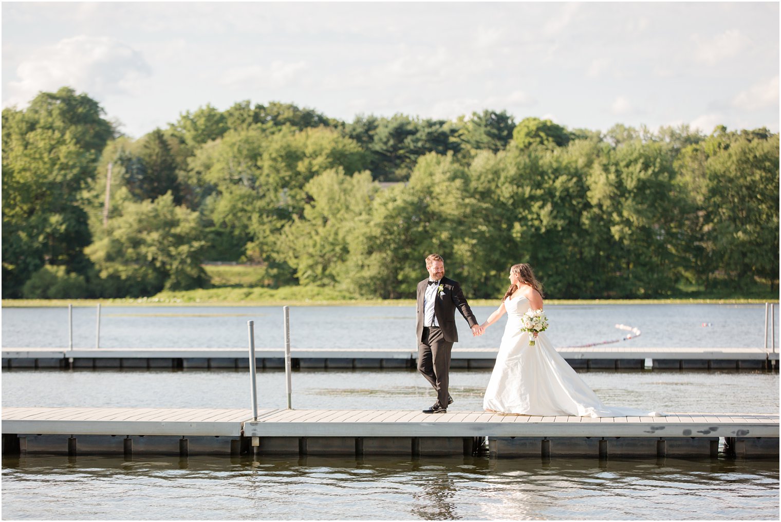 Bride and groom walking out on the dock at Indian Trail Club 