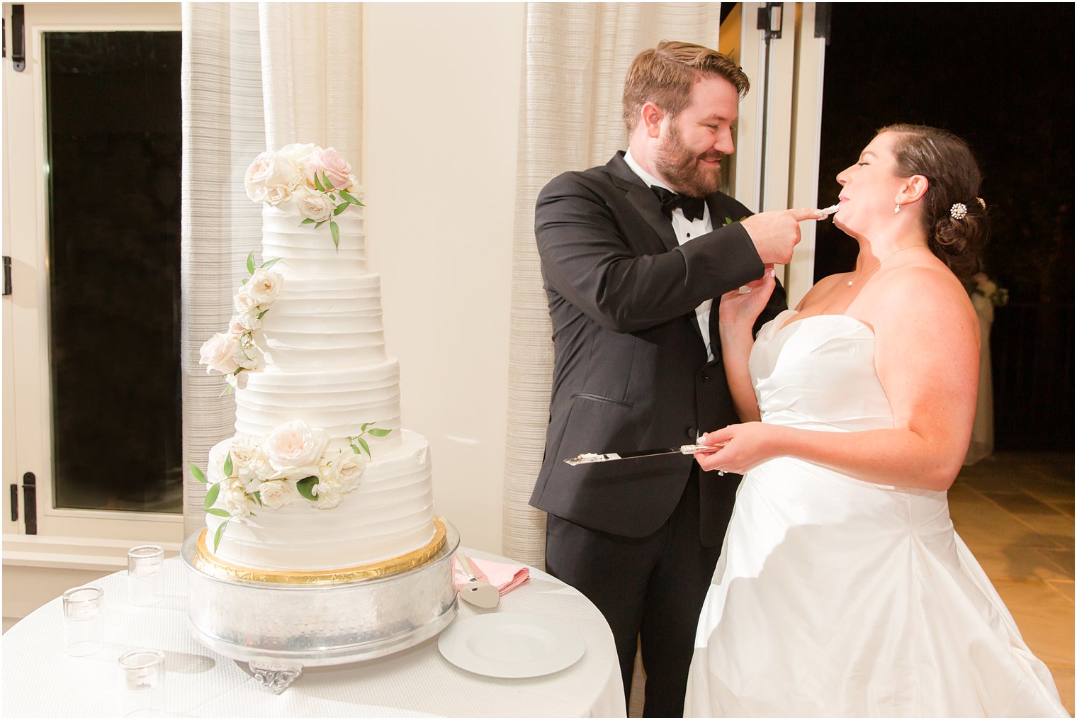 Bride and groom feeding each other wedding cake during wedding reception at Indian Trail Club 