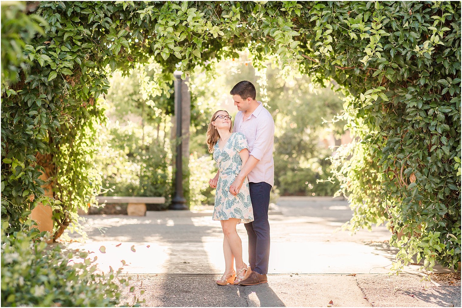 Engagement photo under greenery arch