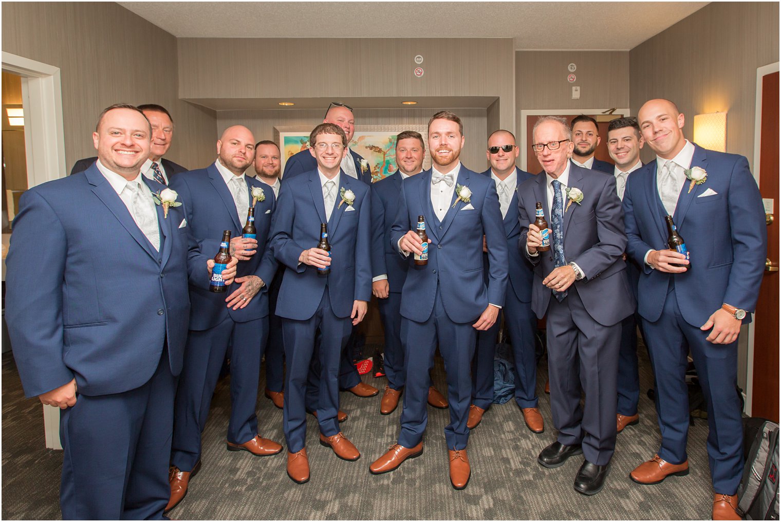 Groom and groomsmen toasting on morning of wedding day 