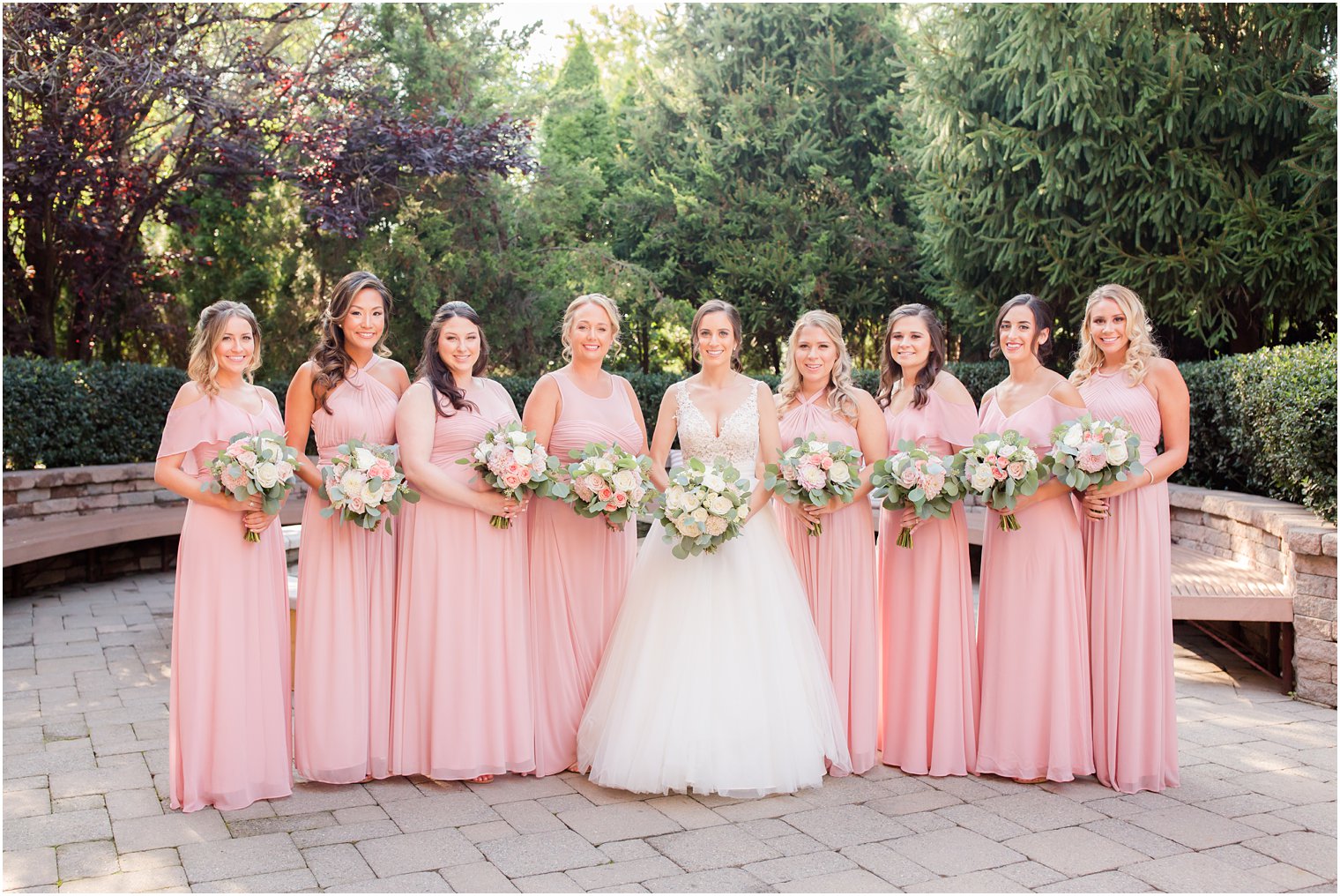Bridesmaids wearing pink with bouquets by Kirk Florist