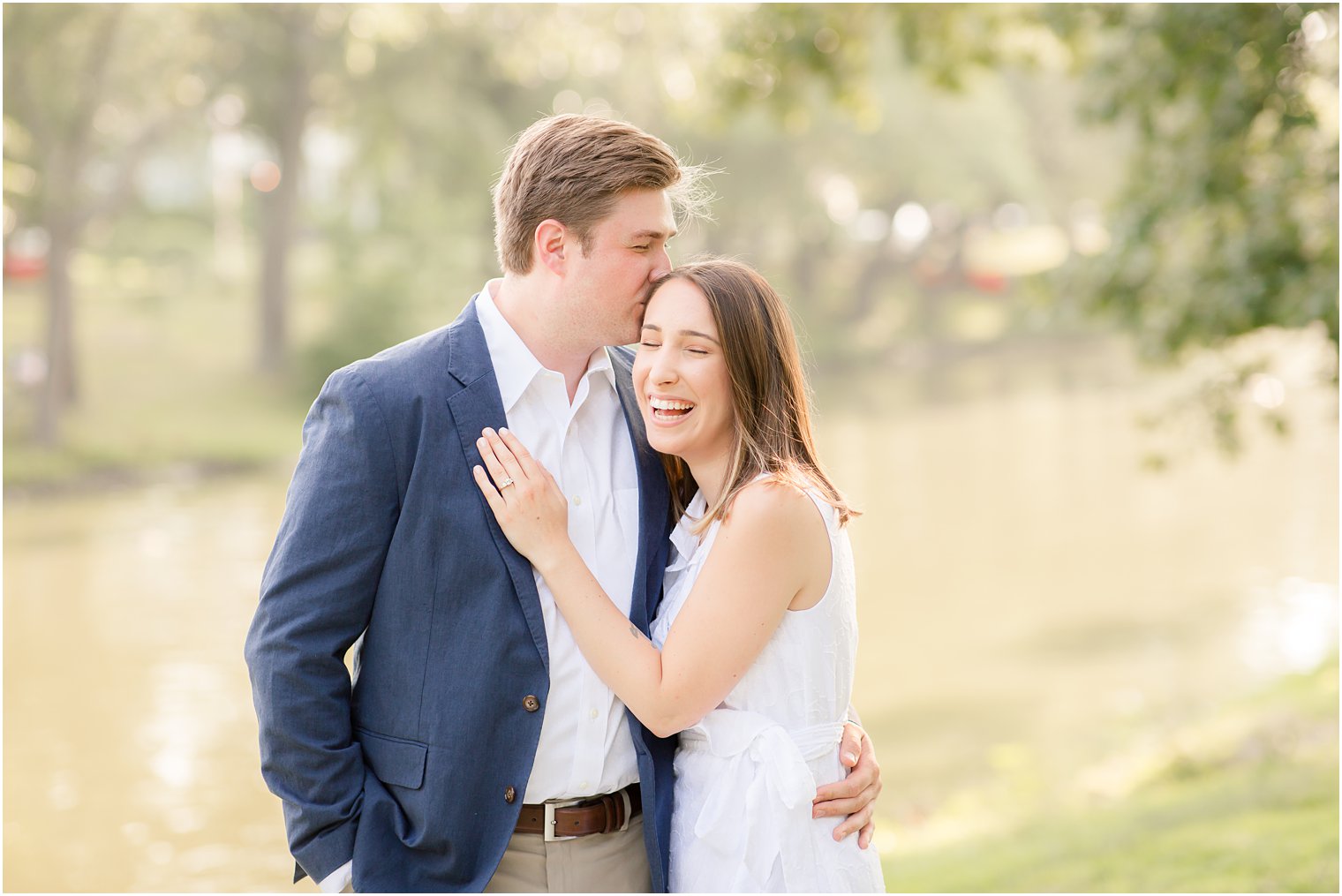 Bride laughing while groom kisses her during Summer Engagement in Spring Lake, NJ