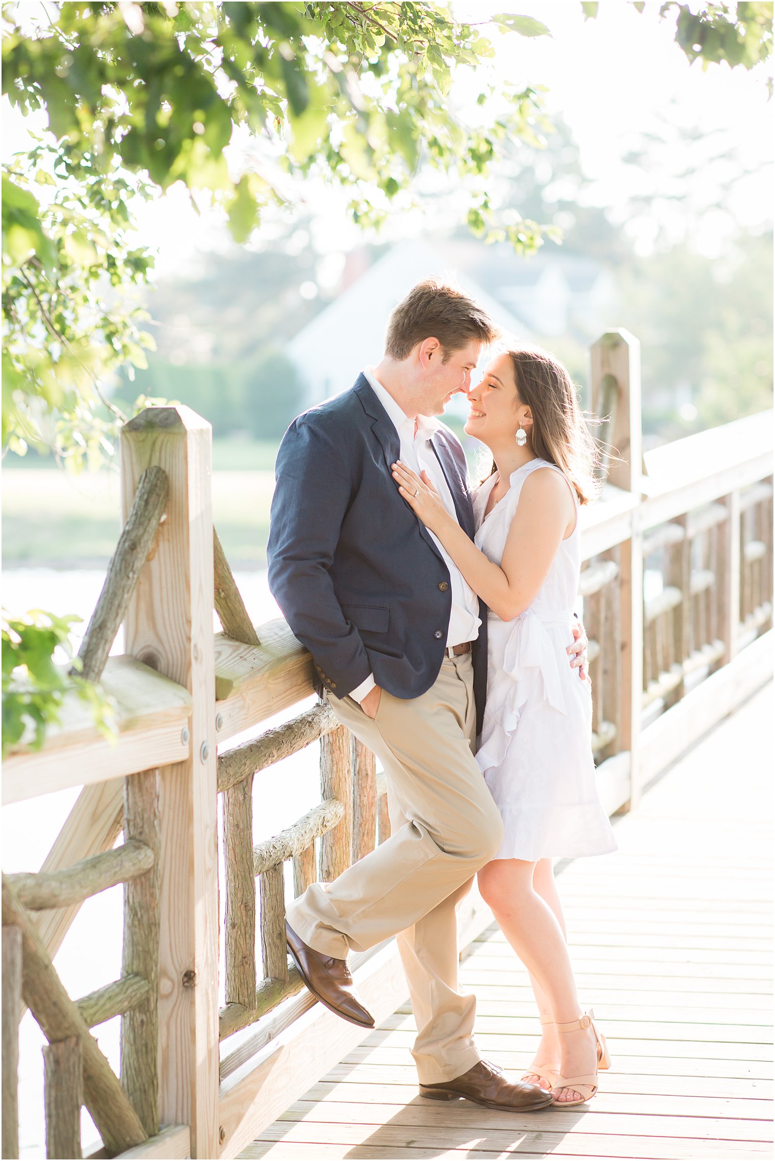Light-filled engagement photo of couple on a bridge in Spring Lake, NJ 