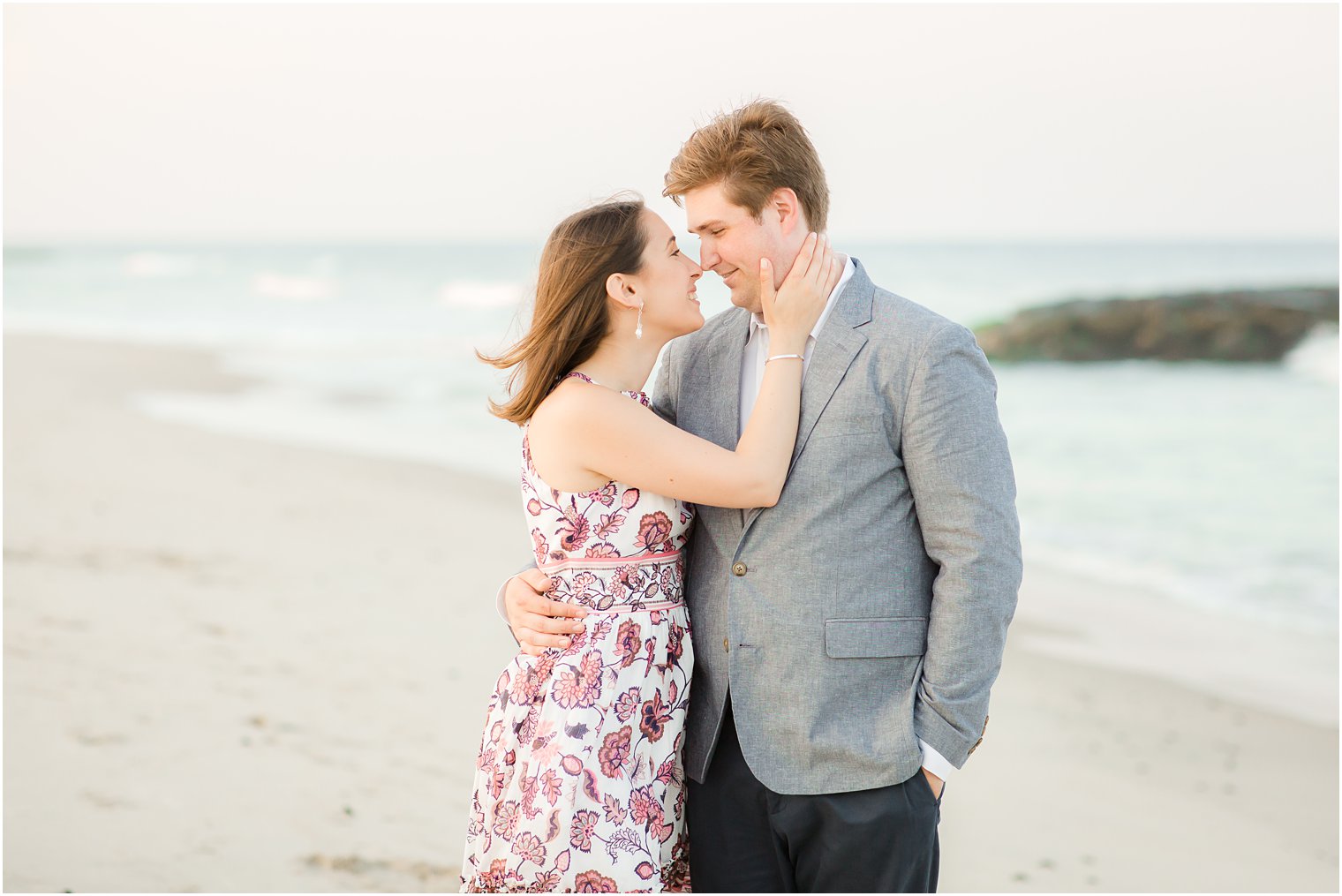Engaged couple kissing on the beach in Spring Lake