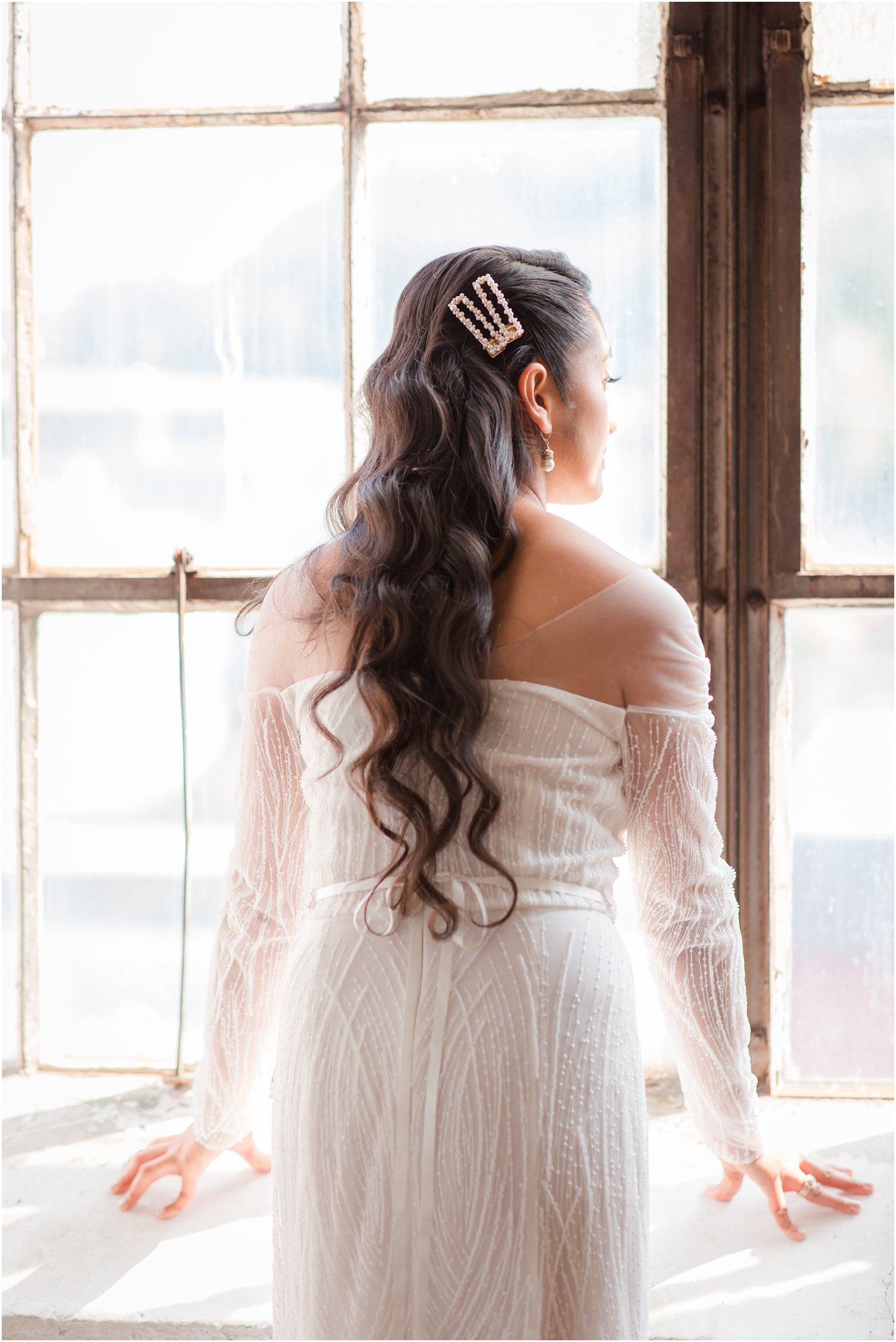 Bride looking out the window on her wedding day 