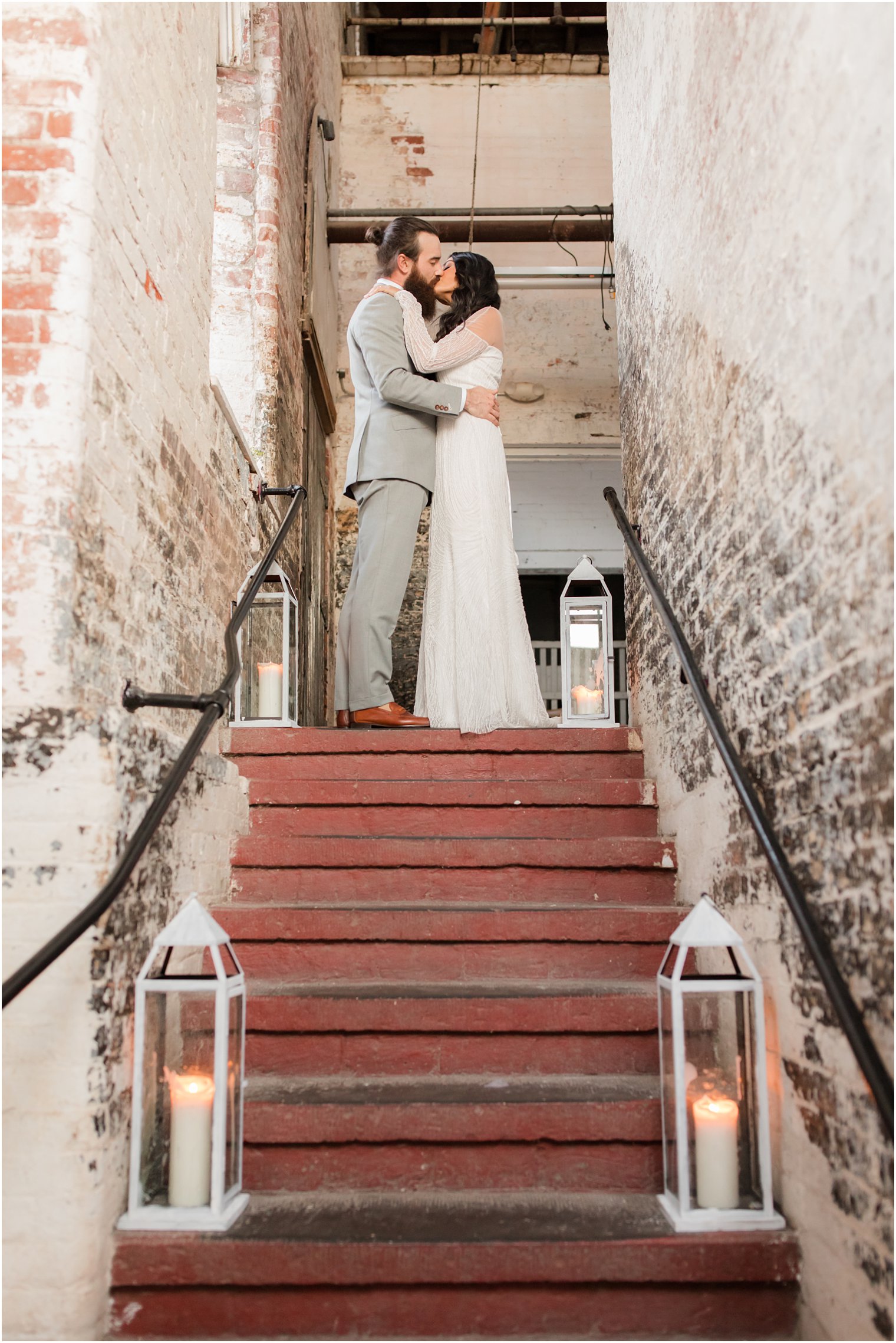 Bride and groom kissing at the top of the steps at the Art Factory in Paterson NJ