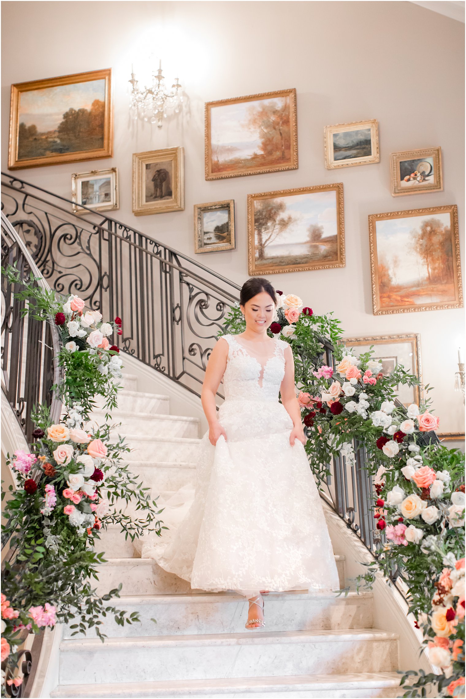 bride walks down floral lined staircase at Park Chateau Estate with Idalia Photography