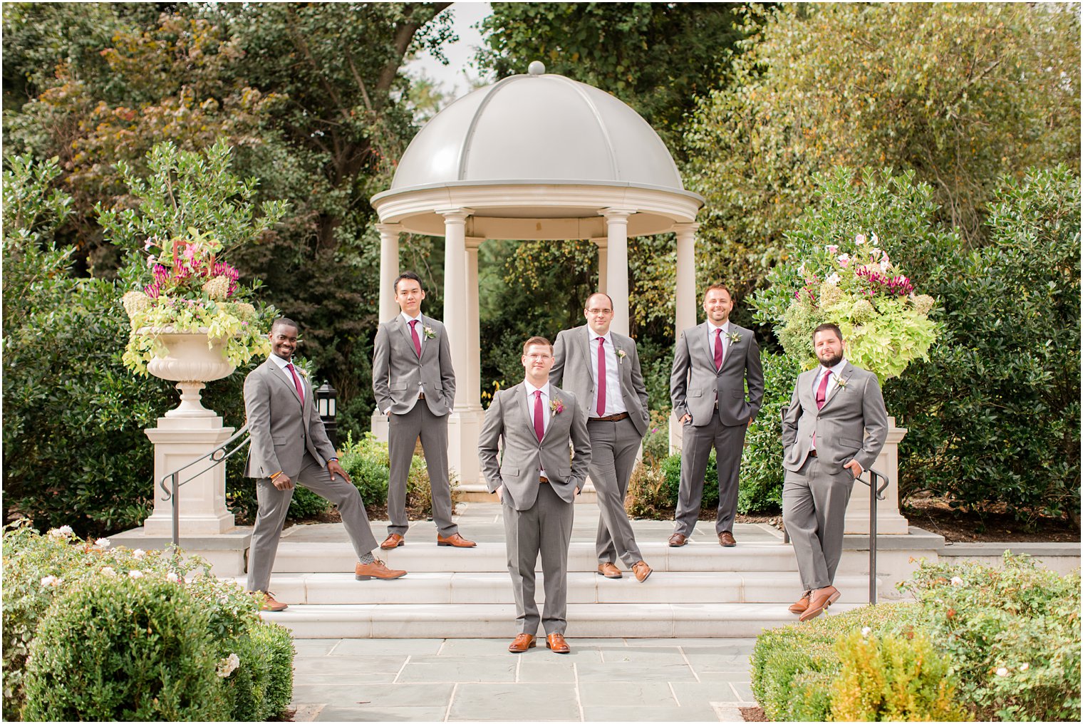 groom and groomsmen pose in Park Chateau Estate gardens with Idalia Photography