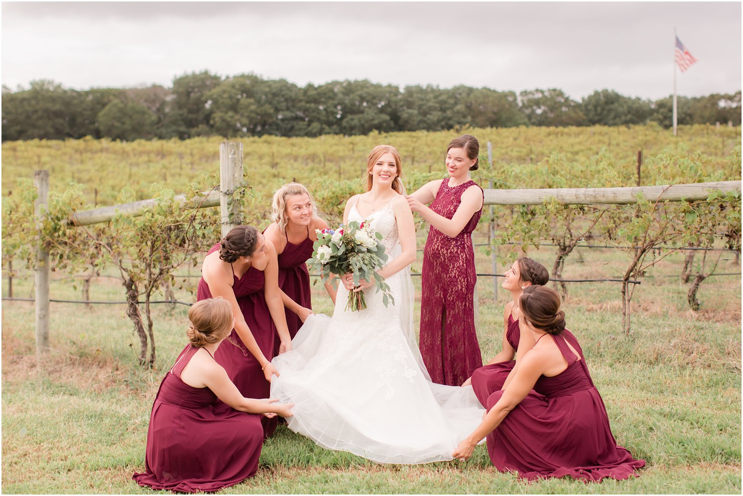Bridesmaids helping bride with her dress at Laurita Winery