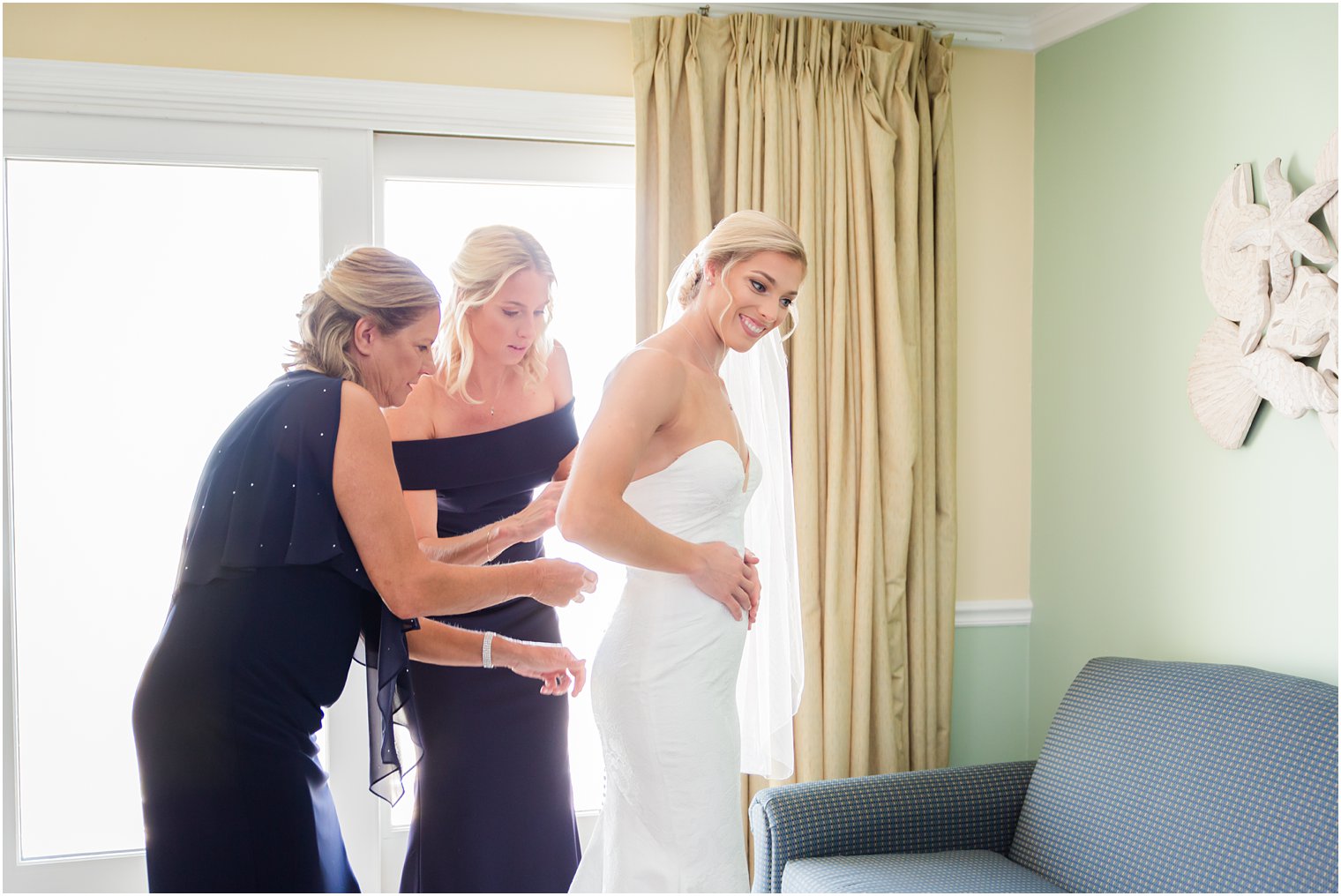 Bridesmaids drinking champagne on bed