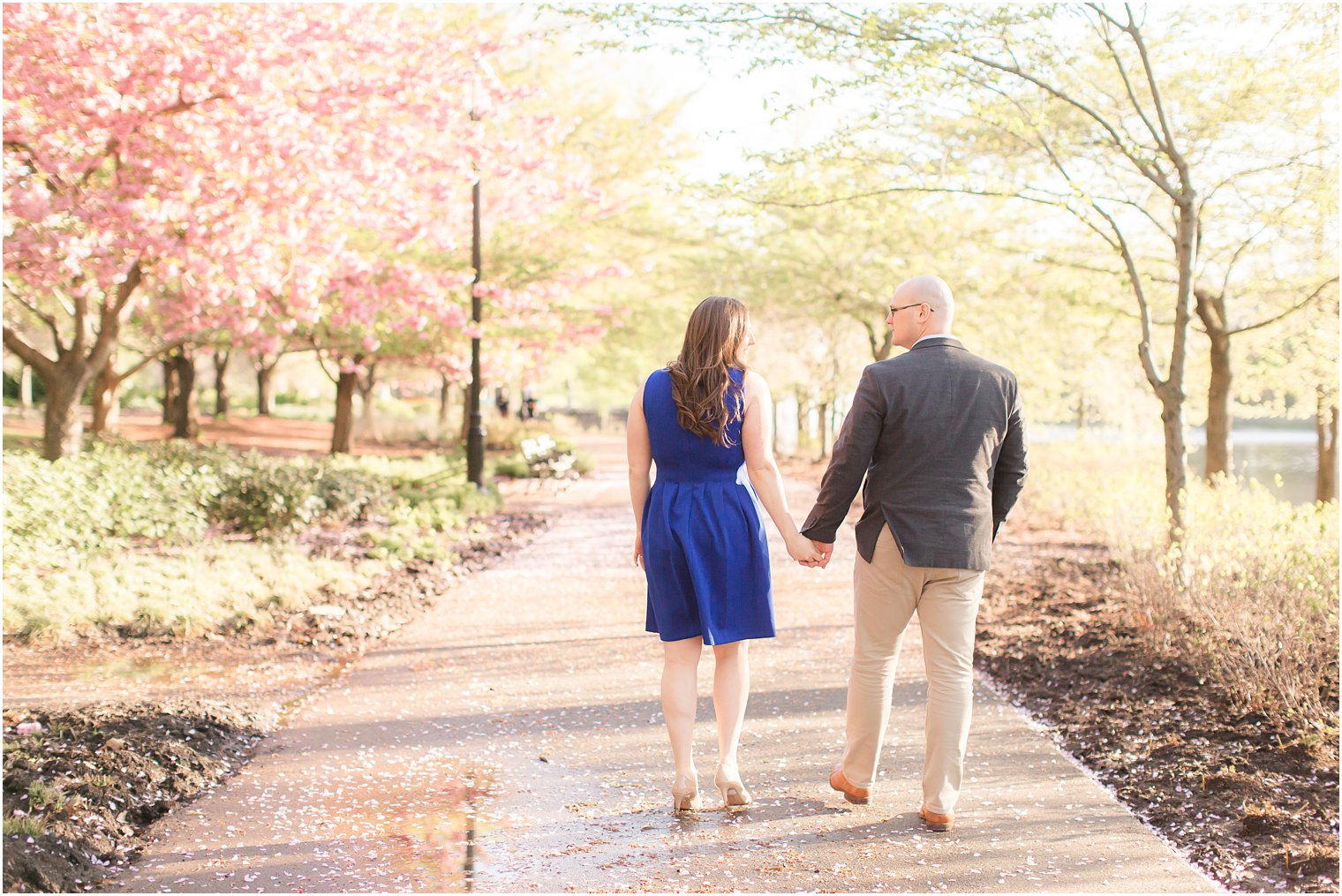 Couple walking away in a tree-lined path