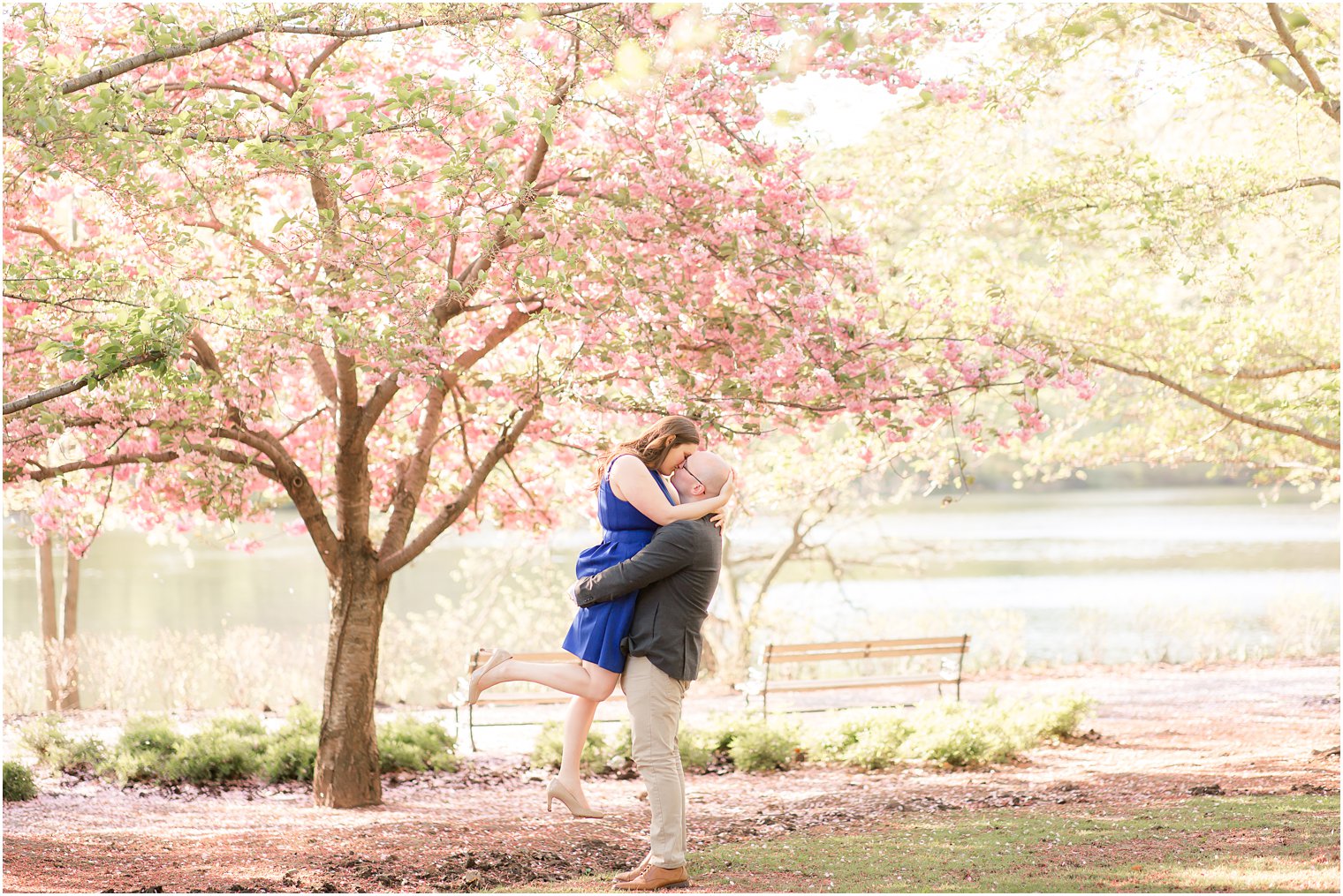 Man lifting woman for a kiss at Branch Brook Park for engagement photo
