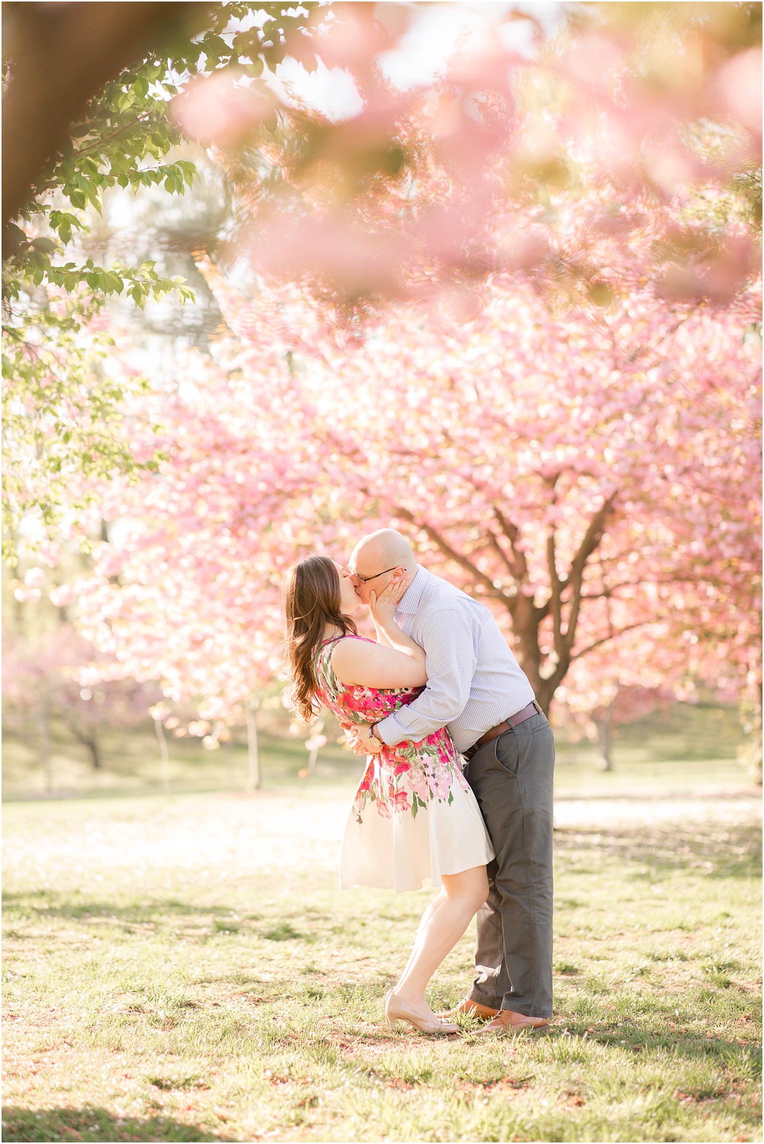 Groom kissing bride under a cherry blossom tree