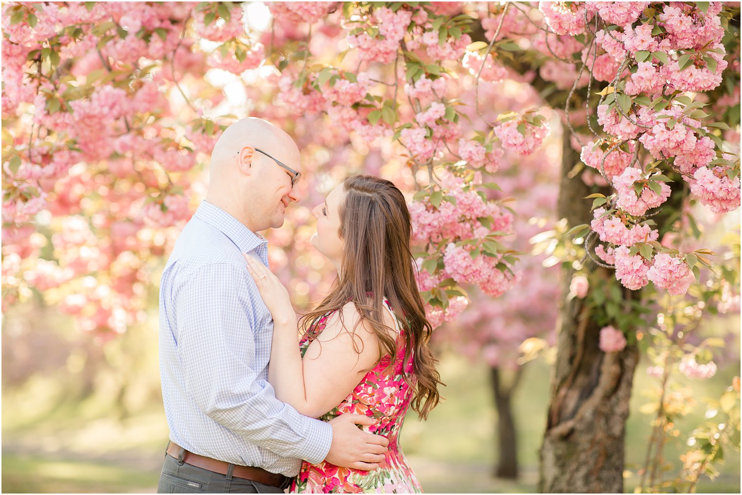 Couple posing for photos among cherry blossoms in Branch Brook Park