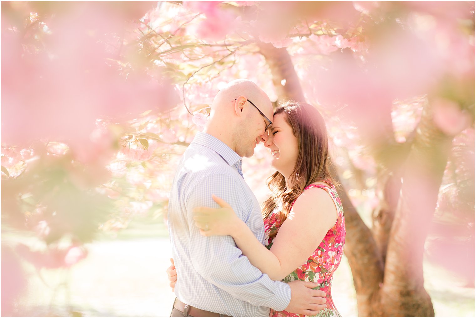 Romantic engagement photo among cherry blossoms at Branch Brook Park