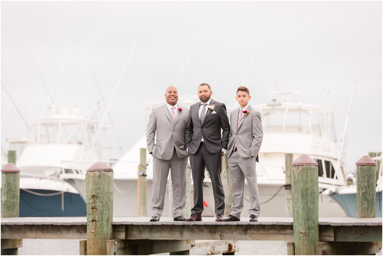 groomsmen and groom pose on pier at Clarks Landing with Idalia Photography