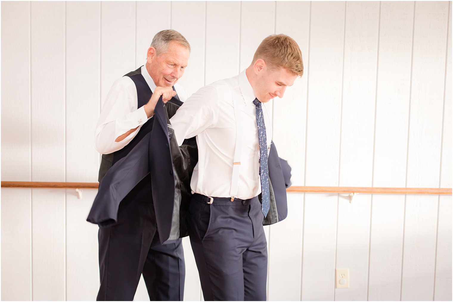 groom gets into jacket for New Jersey wedding day with Idalia Photography