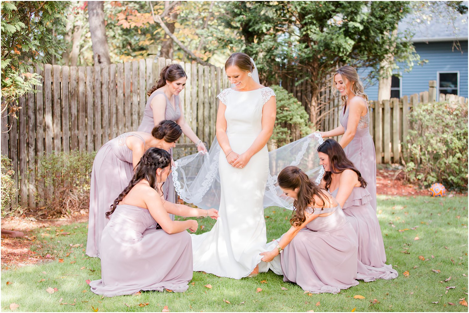 bridesmaids help bride with wedding dress photographed by Idalia Photography
