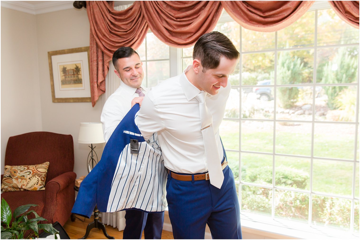 groom gets into navy suit for NY wedding