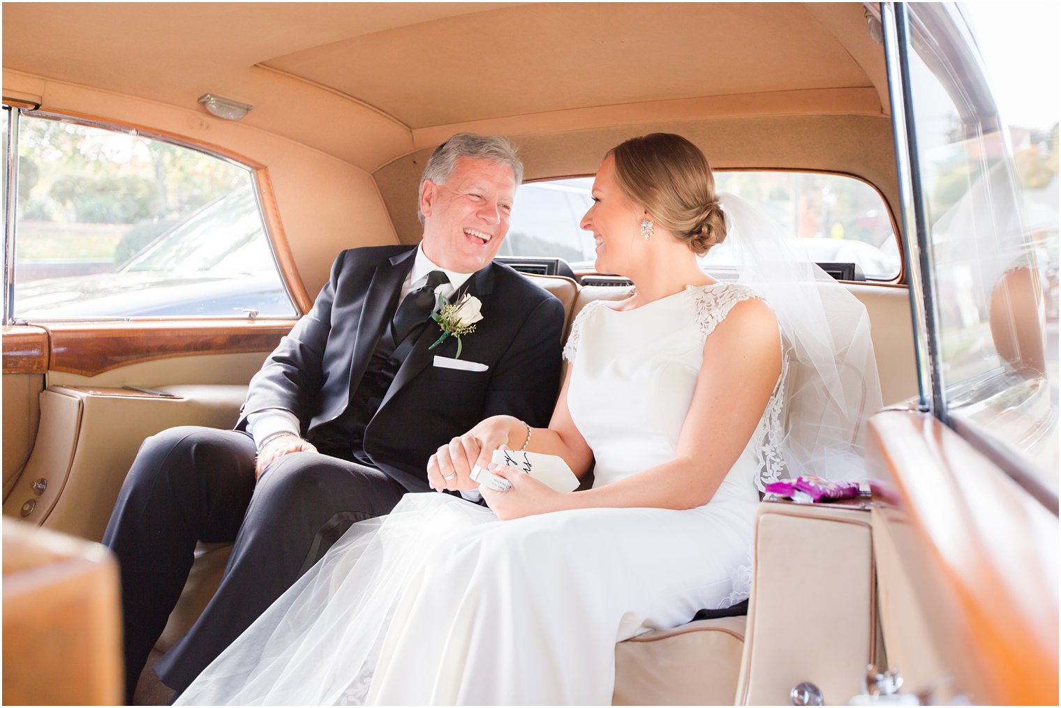 bride and father laugh in classic car with Idalia Photography