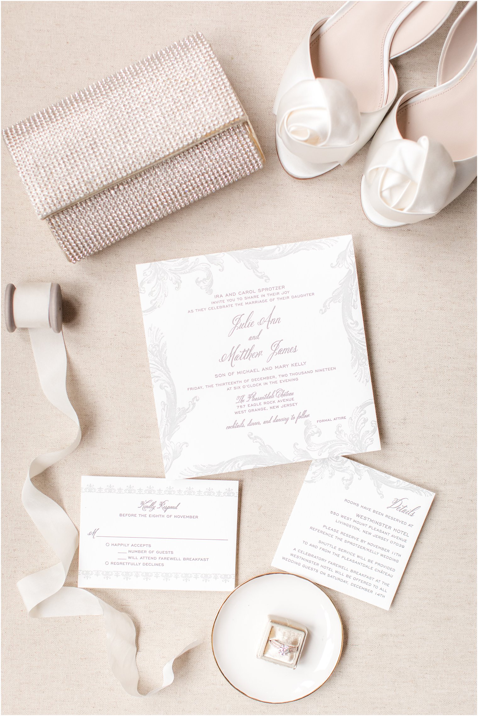 white and silver wedding invitation and gold purse