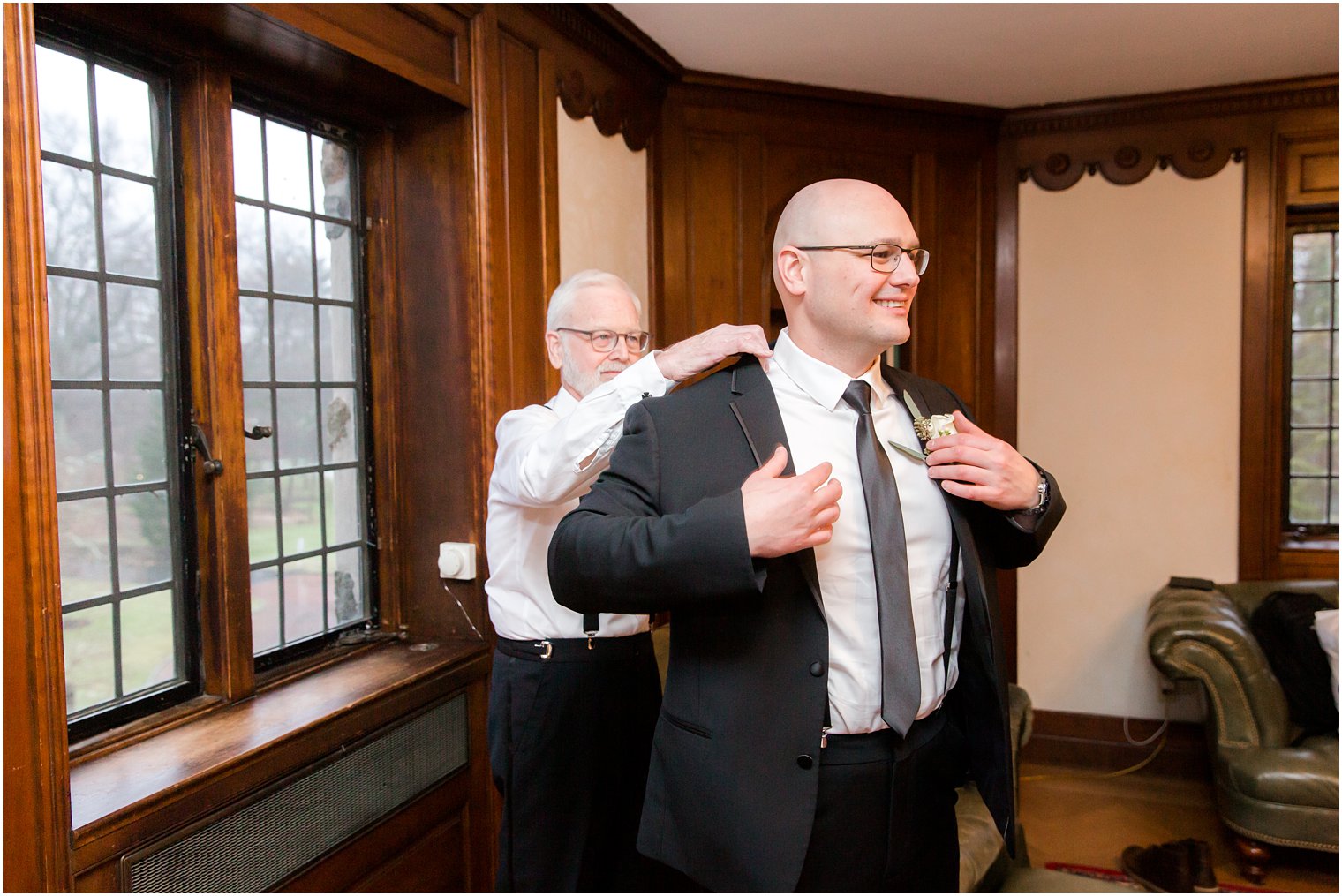 groom's father helping him get dressed on wedding day