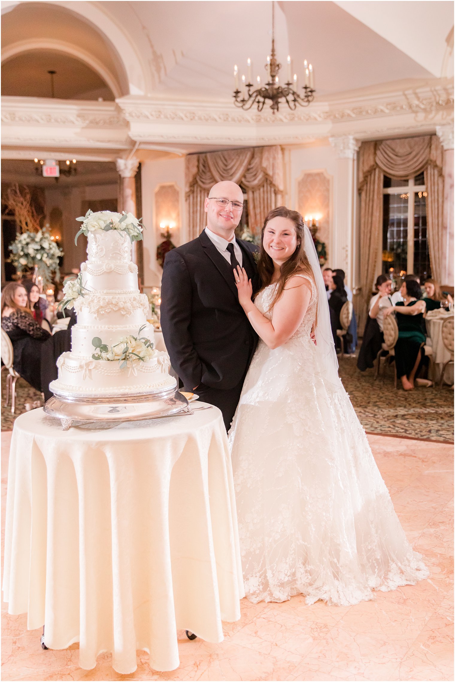 bride and groom posing with their wedding cake at Pleasantdale Chateau winter wedding