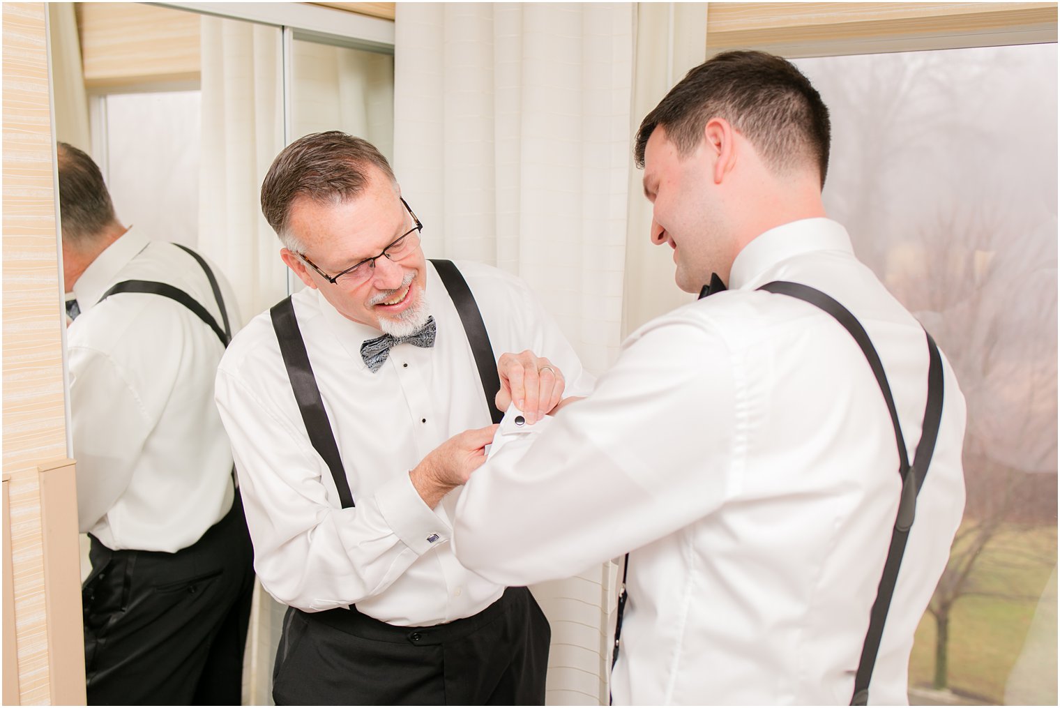 Father of the groom putting on groom's cufflinks