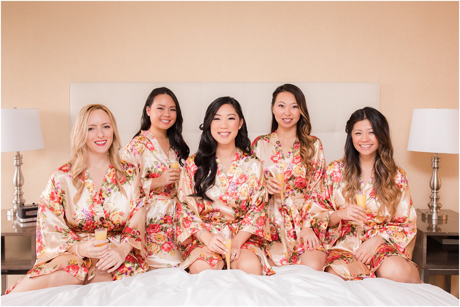 Bride and bridesmaids in robes and drinking mimosas