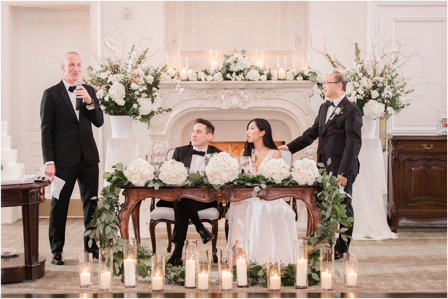 Bride and groom listening to toasts by their fathers