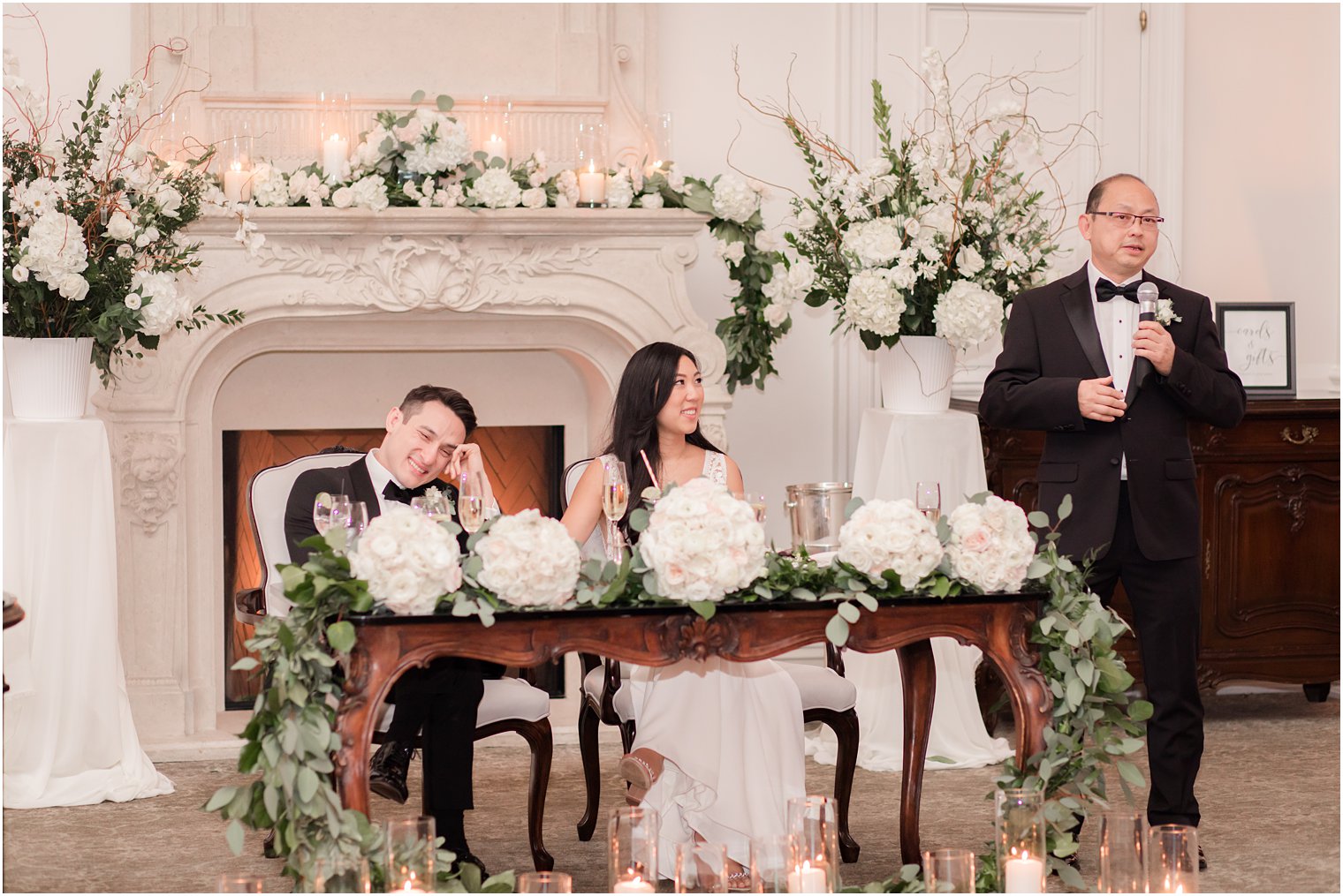 Bride and groom listening to toasts by their fathers