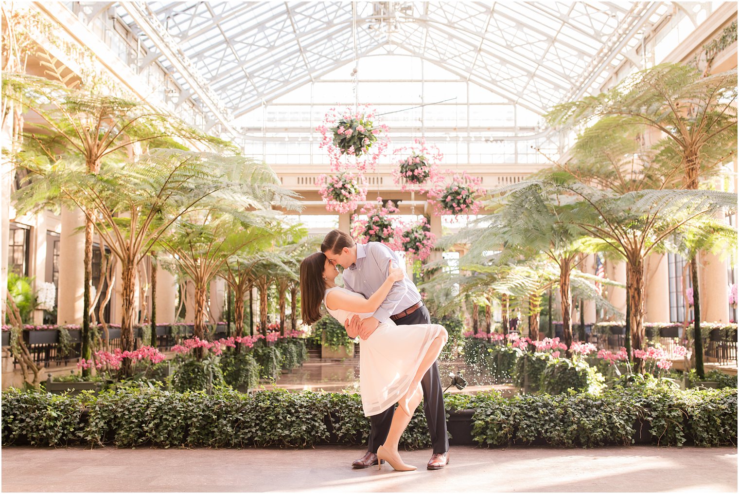 Groom dipping bride during Longwood Gardens Engagement 