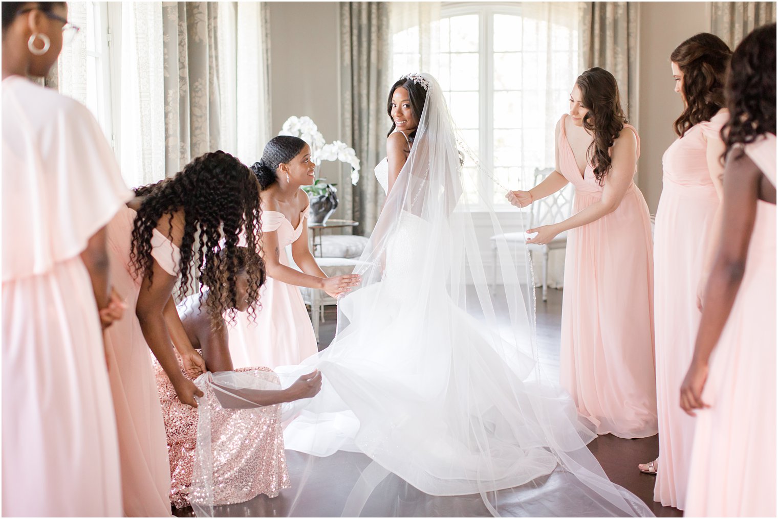 Bridesmaids putting on bride's veil at Park Chateau Estate