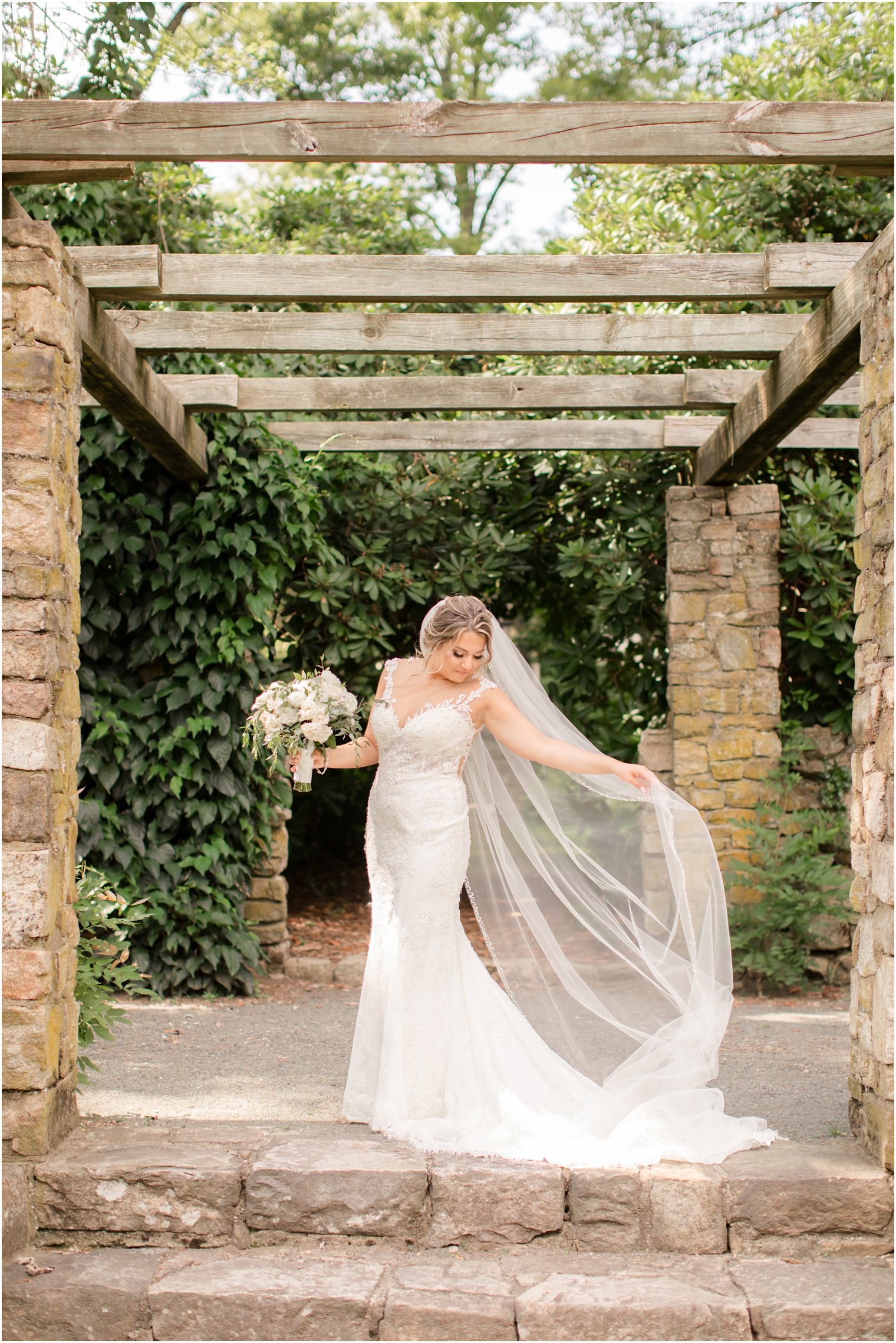 Bride fixing her veil at Cross Estate Gardens